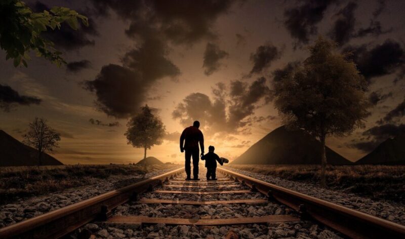 father and son walking railway