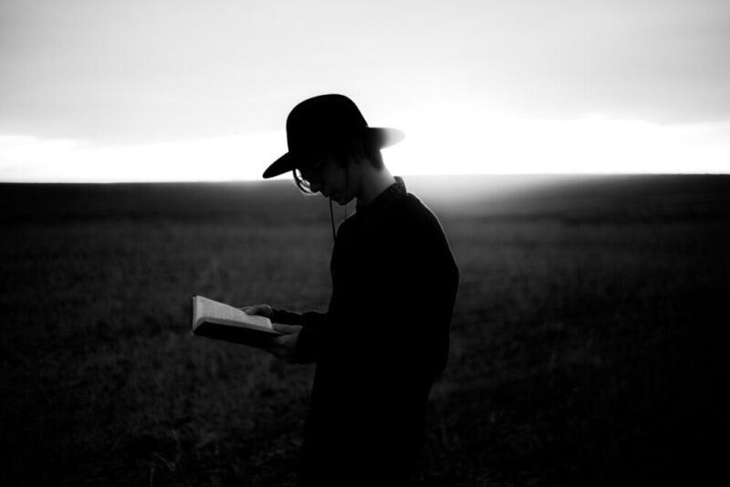 man reading a book in the meadow